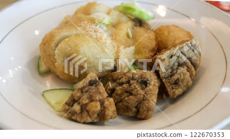 Savor Pempek, savory fishcakes from Palembang, Indonesia, served with sweet and sour kuah cuko sauce. A culinary blend of fish and tapioca, enriched with unique flavors. 122670353