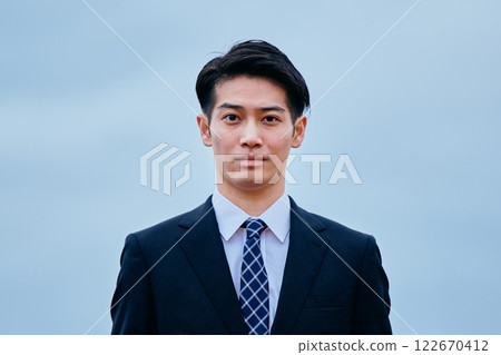 Young man in suit looking at camera, sky Young man in suit looking at camera, sky 122670412