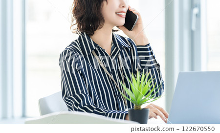 微笑的女人/女商人在智慧型手機上交談 122670550