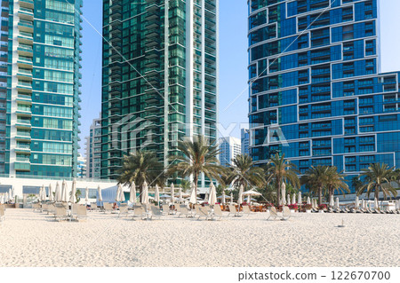 Rows of sun loungers for tourists are displayed against the backdrop of a luxury multi-story hotel 122670700