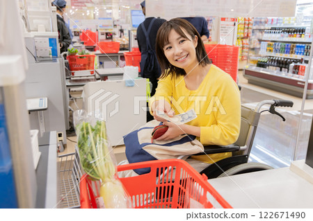 A disabled woman paying at a supermarket (property release obtained) A disabled woman paying at a supermarket (property release obtained) 122671490