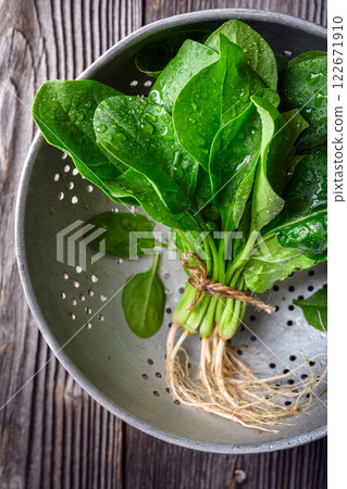 Bunch of fresh green spinach leaves in a metal colander 122671910