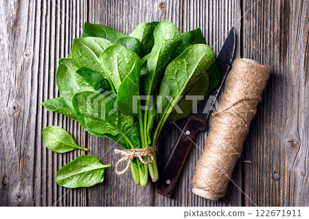 Bunch of fresh green spinach with a skein of twine 122671911
