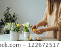 Engaging in Easter Festivities With Colorful Eggs and Spring Flowers in a Bright Indoor Setting 122672517
