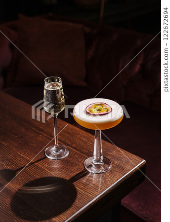 Cocktails on a wooden table with elegant glasses in a cozy lounge setting during the evening 122672694