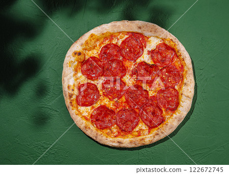 Delicious homemade pepperoni pizza on a green background ready to be enjoyed Delicious homemade pepperoni pizza on a green background ready to be enjoyed 122672745