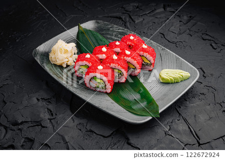 Colorful sushi rolls arranged on a decorative plate with wasabi and ginger served in a stylish dining setting Colorful sushi rolls arranged on a decorative plate with wasabi and ginger served in a stylish dining setting 122672924