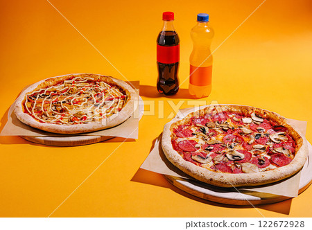 Delicious pizzas and refreshing drinks on vibrant yellow backdrop for a fun dining experience 122672928