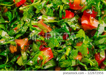 Freshly chopped parsley and tomatoes create a vibrant salad mix in a kitchen setting 122672956