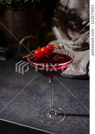 Elegant cocktail with cherry garnish served in a stylish glass on a dark countertop at a bar in the evening Elegant cocktail with cherry garnish served in a stylish glass on a dark countertop at a bar in the evening 122673001