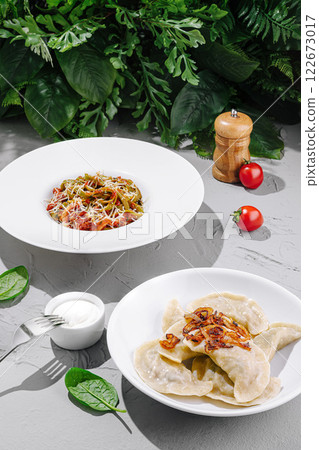 Delicious plate of fresh pasta and dumplings served with herbs and vegetables in a bright setting 122673017