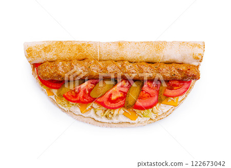 Savory wrap filled with grilled meat, fresh vegetables, and cheese served on a flatbread Savory wrap filled with grilled meat, fresh vegetables, and cheese served on a flatbread 122673042