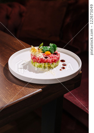 Creative culinary presentation of a vibrant dish featuring colorful ingredients on a round plate 122673049