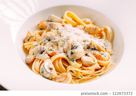 Portion of fettuccine alfredo pasta with chicken 122673372