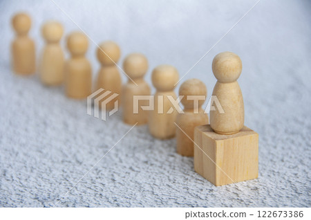 A wooden figure doll leading other figure dolls with customizable space for text. Leadership concept A wooden figure doll leading other figure dolls with customizable space for text. Leadership concept 122673386