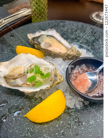 Fresh oysters on ice, lemon wedges, gourmet seafood, fine dining. High quality photo 122673447