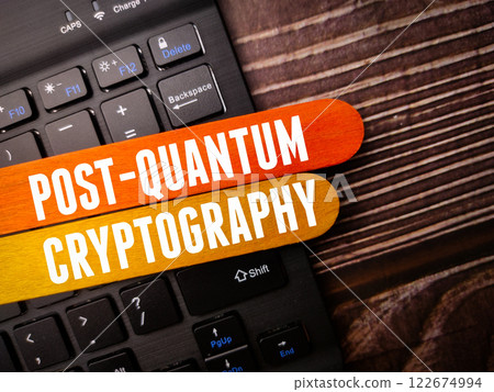 Black keyboard with the word POST QUANTUM CRYPTOGRAPHY on a wooden background. 122674994