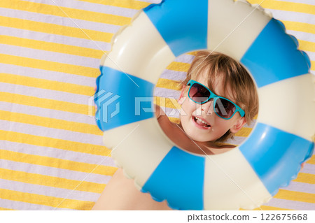 Top view portrait of happy child lying on beach towel on summer vacation 122675668