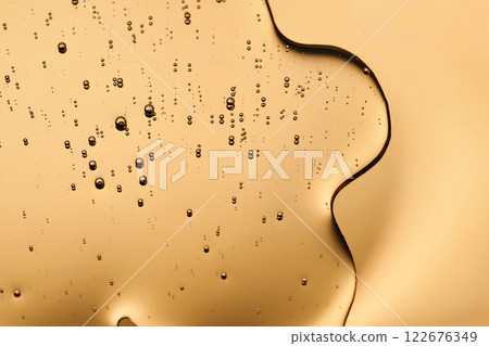 Tasty texture of cosmetic gel on a golden background. Tasty texture of cosmetic gel on a golden background. 122676349