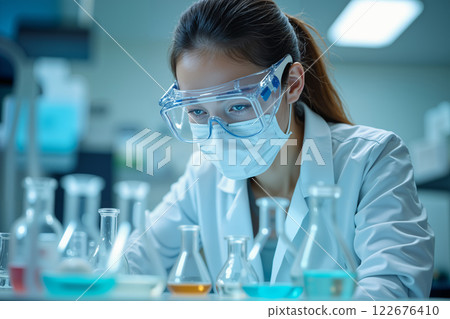 Scientist examines beakers and test tubes. 122676410