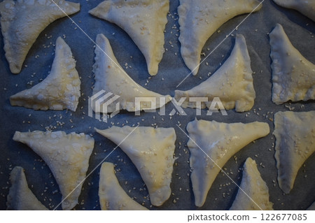 Ready to Bake: A Tray of Golden Pastries with Sesame Seeds 122677085