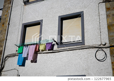 Colorful laundry hanging on urban building wall with closed windows 122677965