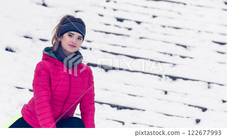Woman wearing sportswear exercising during winter Woman wearing sportswear exercising during winter 122677993