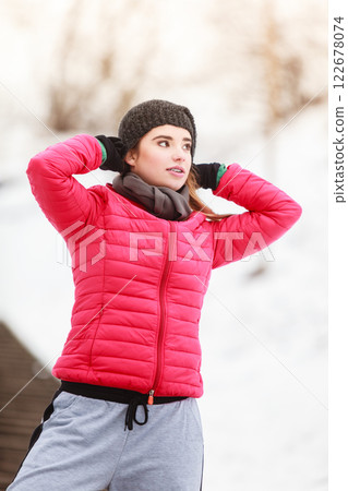 Woman wearing sportswear exercising outside during winter Woman wearing sportswear exercising outside during winter 122678074