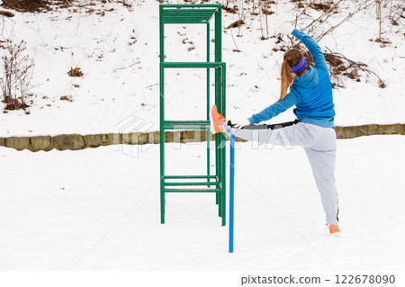Woman wearing sportswear urban exercising outside during winter 122678090