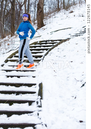 Woman wearing sportswear exercising outside during winter 122678145