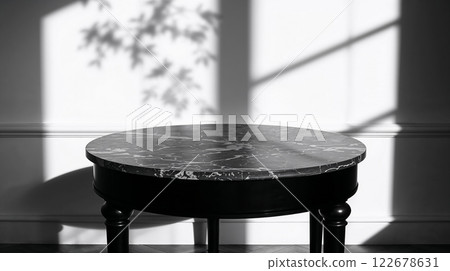 Sunlight casting shadows on elegant round marble table in black and white 122678631