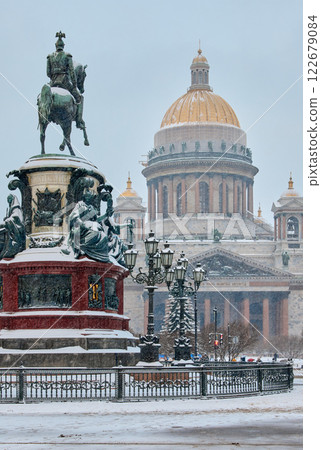 a snow-covered New Year's city decorated for the celebration of the new year, the golden dome of St. Isaac's Cathedral, walking tourists 122679084