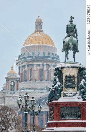 a snow-covered New Year's city decorated for the celebration of the new year, the golden dome of St. Isaac's Cathedral, walking tourists 122679085