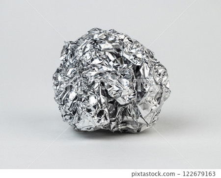 Crumpled aluminum foil resting on a plain surface Crumpled aluminum foil resting on a plain surface 122679163
