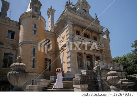 A woman is standing on a set of stairs in front of a large building 122679383