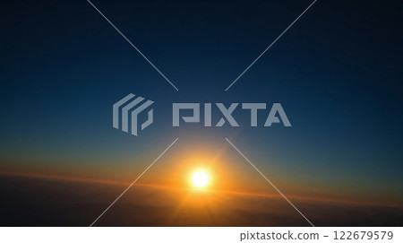 Majestic sunrise illuminating clouds from above in a clear sky Majestic sunrise illuminating clouds from above in a clear sky 122679579