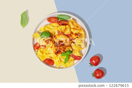 Tagliatelle or pappardelle pasta with tomato sauce, basil and parmesan cheese in a plate Tagliatelle or pappardelle pasta with tomato sauce, basil and parmesan cheese in a plate 122679615