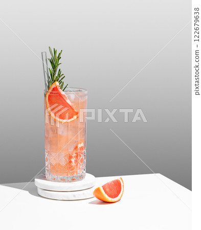 Refreshing mocktail with grapefruit, rosemary and ice in a glass on a gray background Refreshing mocktail with grapefruit, rosemary and ice in a glass on a gray background 122679638
