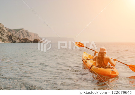 Kayak sea woman. Happy attractive woman with long hair in red swimsuit, swimming on kayak. Summer holiday vacation and travel concept. 122679645
