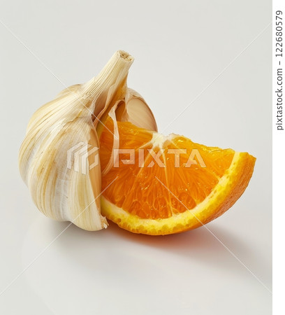 This striking subject showcases a garlic clove with a bright orange segment nestled within. The contrast between the white garlic and orange creates an intriguing visual 122680579