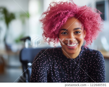 A joyful black woman in a wheelchair showcases her vibrant pink afro hair, embodying inclusivity in a lively office space A joyful black woman in a wheelchair showcases her vibrant pink afro hair, embodying inclusivity in a lively office space 122680591