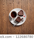 Heart shaped chocolate brownie and hot coffee on a white round plate, wood grain background. AI generated image. 122680780