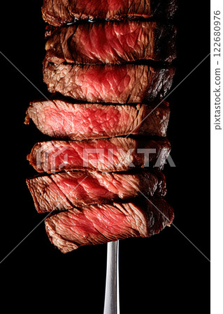 Beef steak on a fork over a black background. Ai Generative Beef steak on a fork over a black background. Ai Generative 122680976