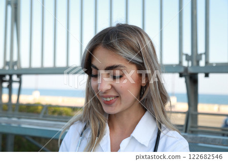 Female Doctor Sitting And Smiling Outdoor Female Doctor Sitting And Smiling Outdoor 122682546
