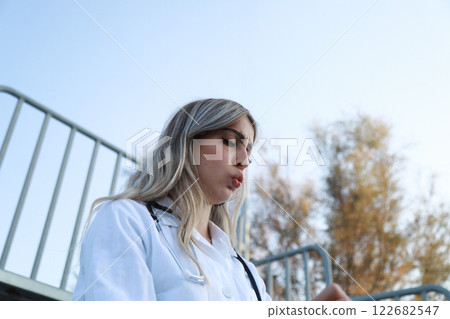 Woman Doctor Reacting To A Message on Her Phone 122682547