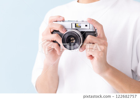 Man holding a film camera (stock photo) 122682757