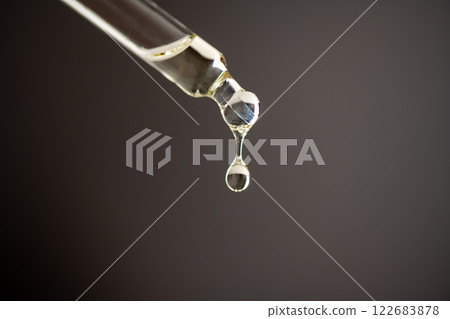 Essential oil, closeup pipette on dark background. Skin care. Moisturizing skin care product.  122683878