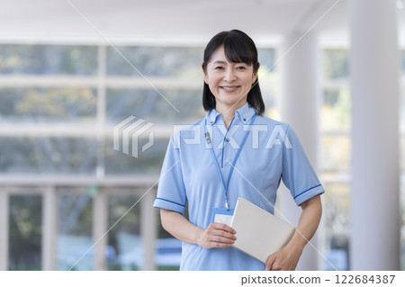 一名女性工作人員手持平板電腦，微笑地看著鏡頭 122684387