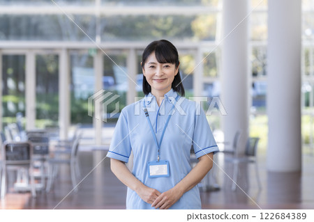 一名 50 多歲的女性設施工作人員身穿藍色 Polo 衫，正看著鏡頭 122684389