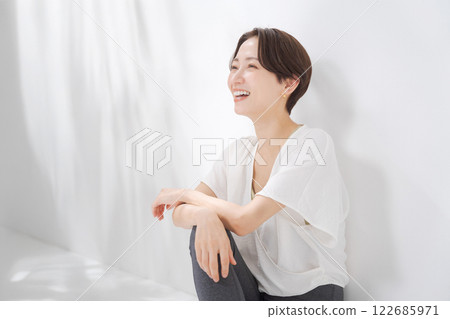A woman in her 30s sitting in yoga wear 122685971